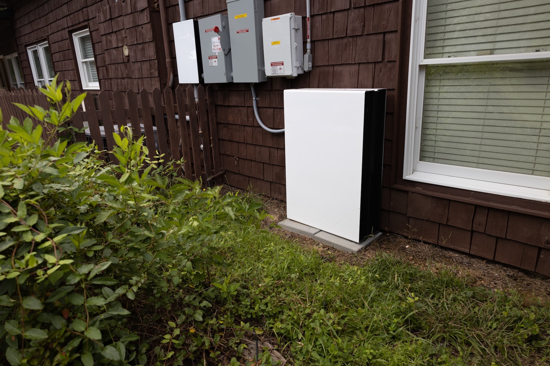 Solar battery backup on side of brown home